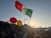 A huge crowd in a Boyle Heights 1st Street celebrating Mexico's win with a Mexican flag in the air
