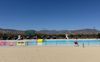 The empty Hansen Dam pool with a tiny screen to watch the World Cup and a lifeguard walking in front of a fence