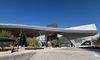 The Hollywood Burbank Airport with a swooping canopy over the pickup area and a worker putting final touches on a shaded bench