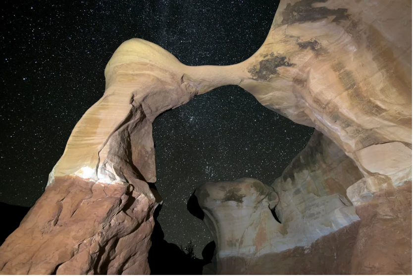 A natural arch with a star-filled sky in the Grand Staircase-Escalante National Monument