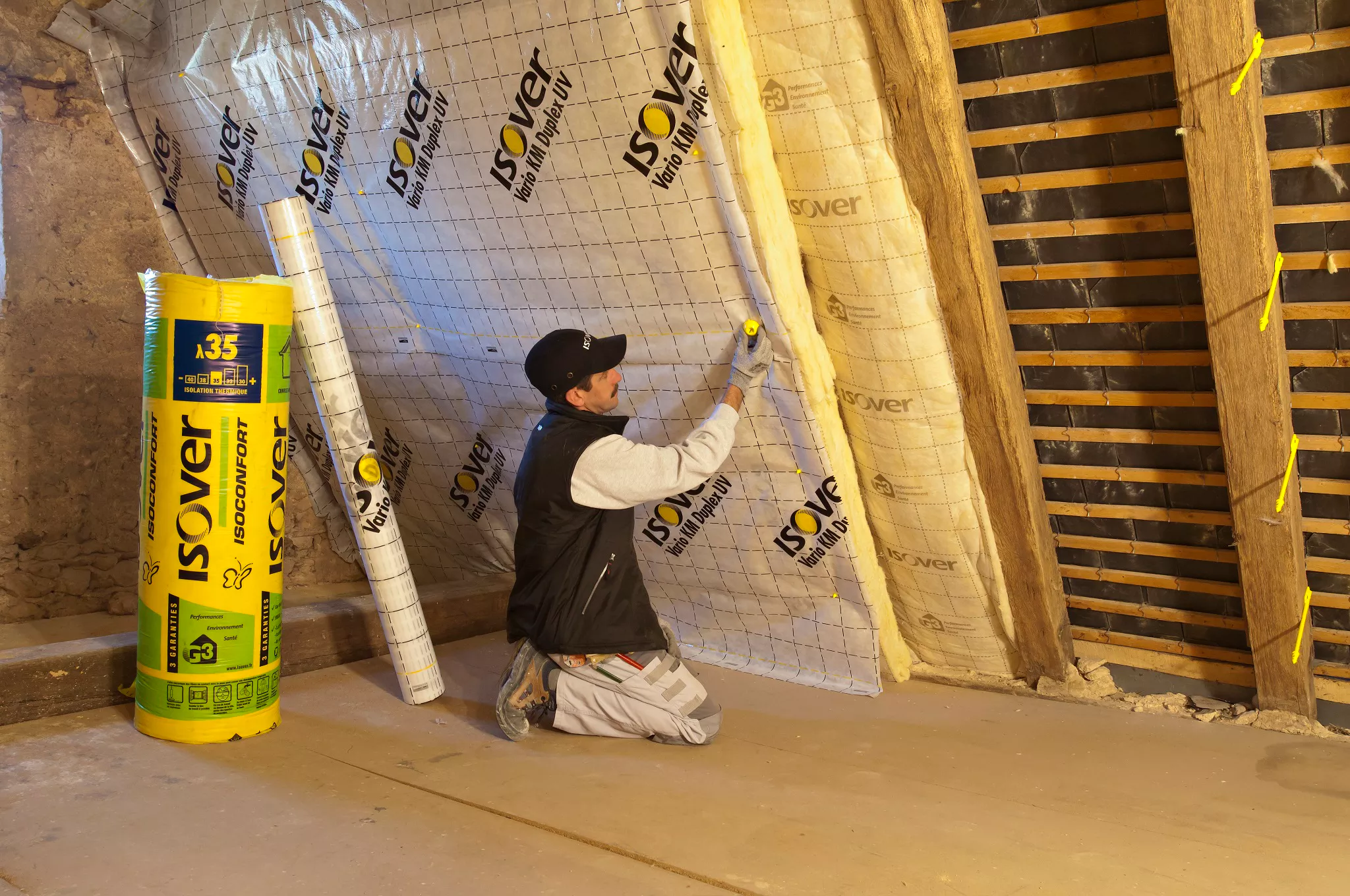 Un artisan installe une membrane d'étanchéité Isover.