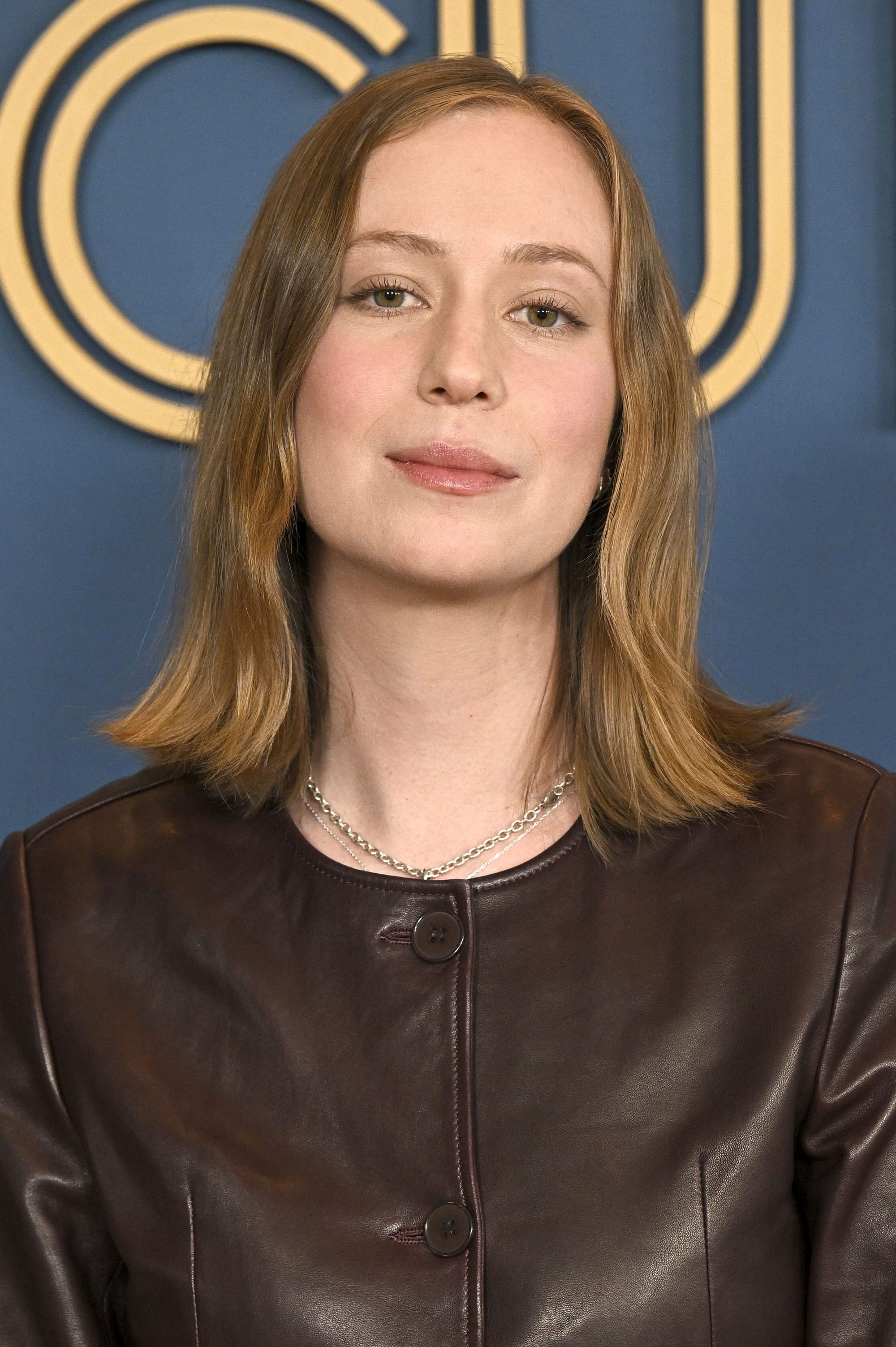 Portrait of Hannah Einbinder, wearing a brown leather jacket