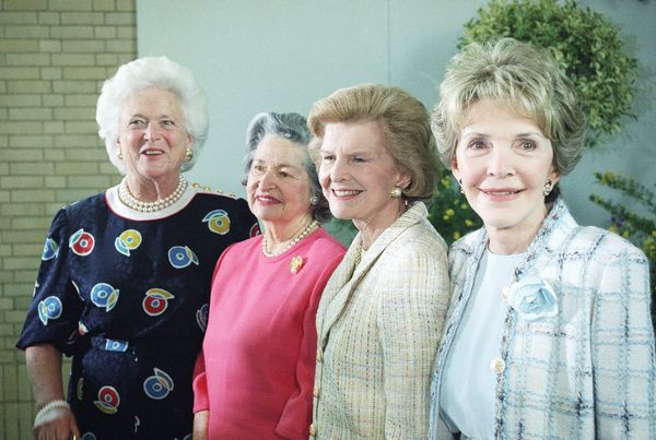 Former first ladies Barbara Bush, Lady Bird Johnson, Betty Ford and Nancy Reagan stand in a row.