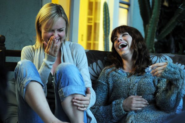 Women laughing on a couch.