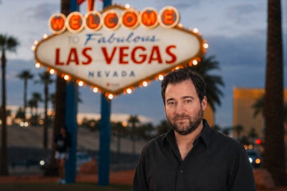 Man in front of Las Vegas sign.