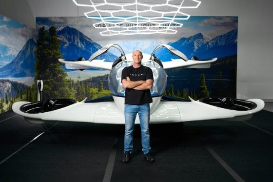 A man standing in front of a futuristic-looking vehicle.