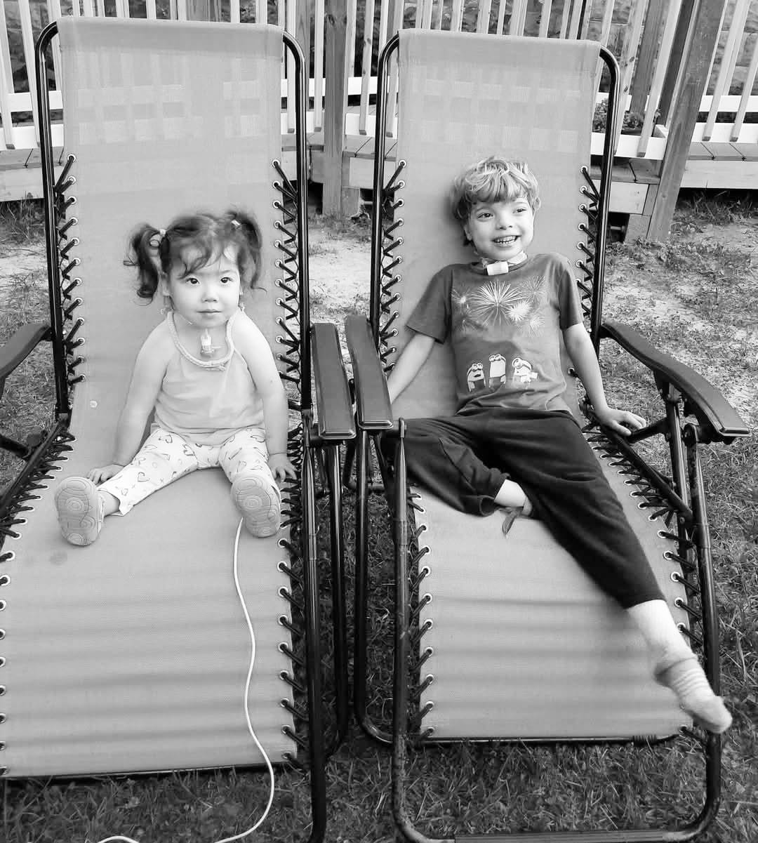 Xiomara and Jimmy sit outside on matching lounge chairs.