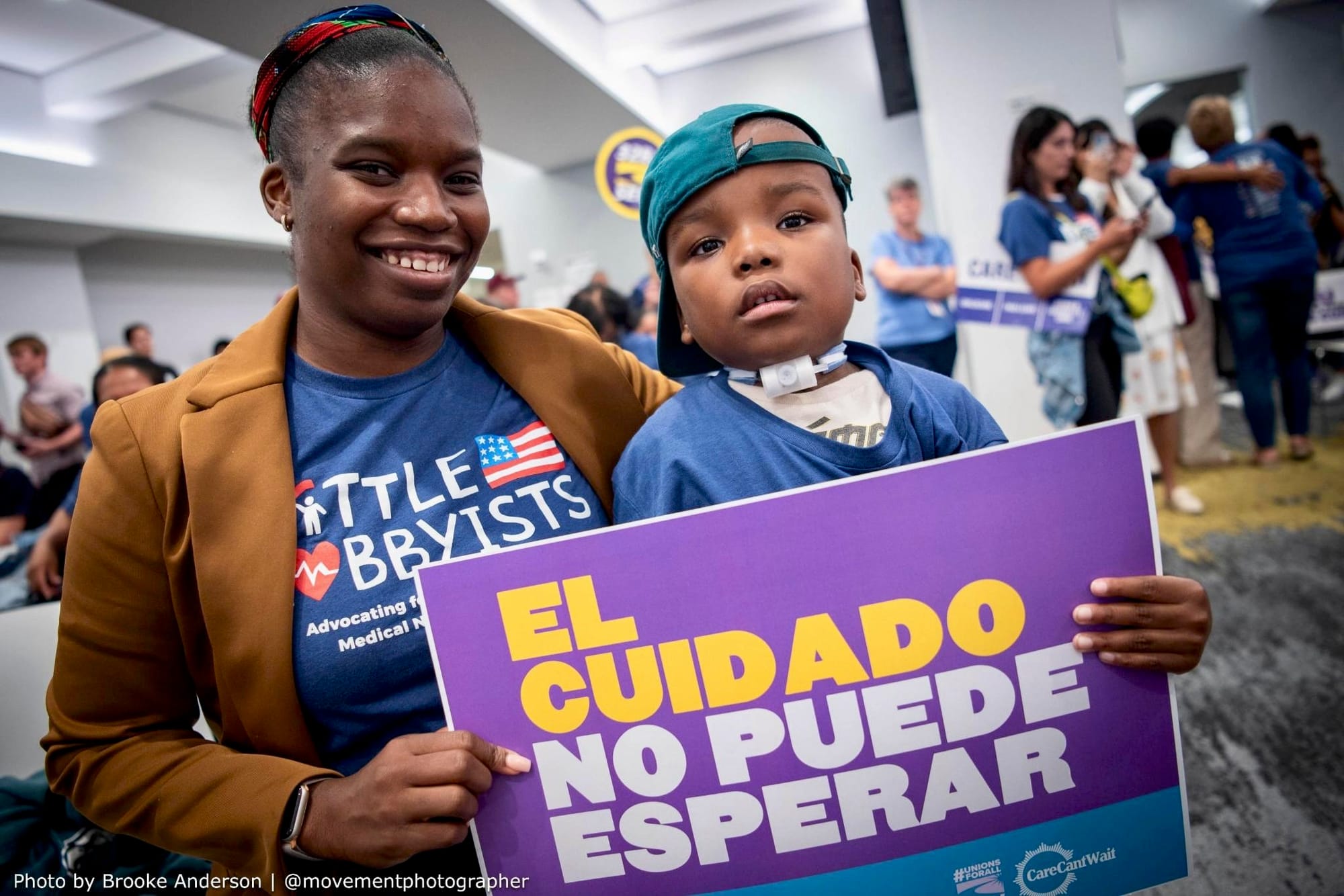 Photo of Little Lobbyist Adonise with his mom Anne in New York, holding a sign that says “El Cuidado No Puede Esperar” (“Care Can’t Wait” in Spanish).