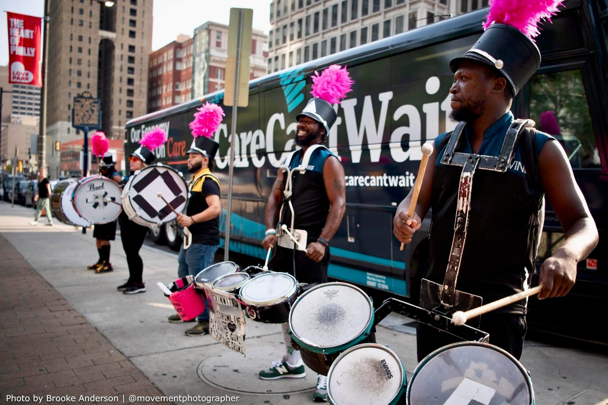 Photo of marching band performing in front of the Care Can’t Wait bus.