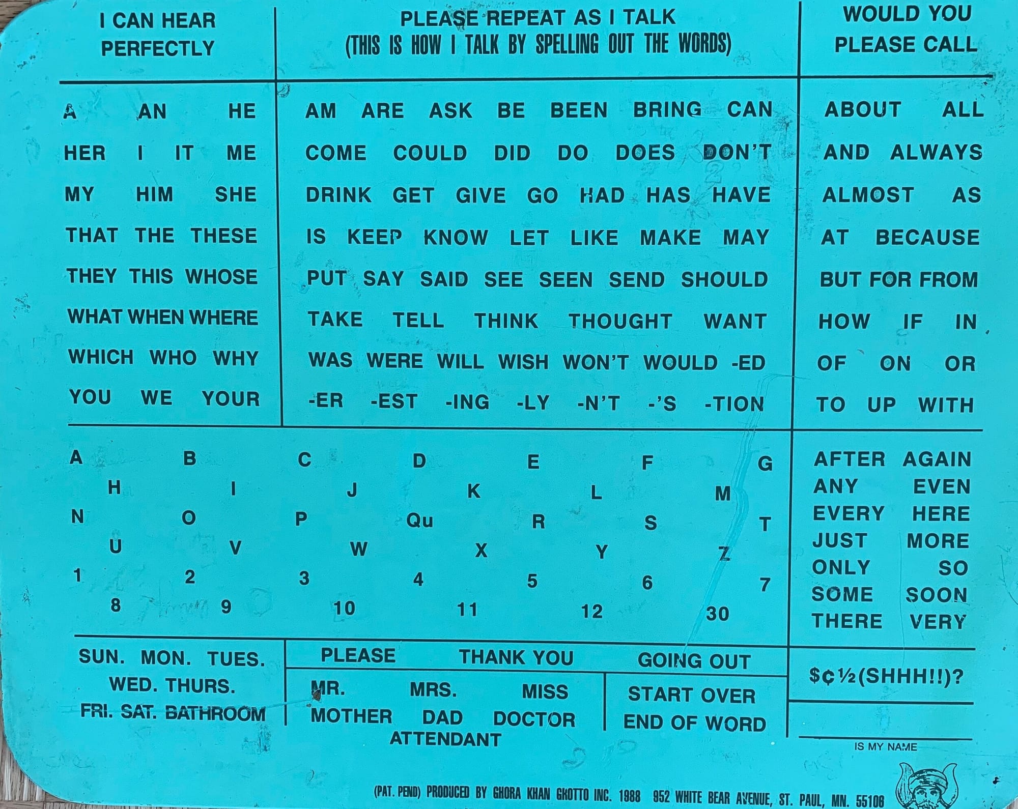 A Hall Roe Communication Board. Image of a board with a blue background covered in sections of black type that include commonly used words and phrases, as well an as alphabet.