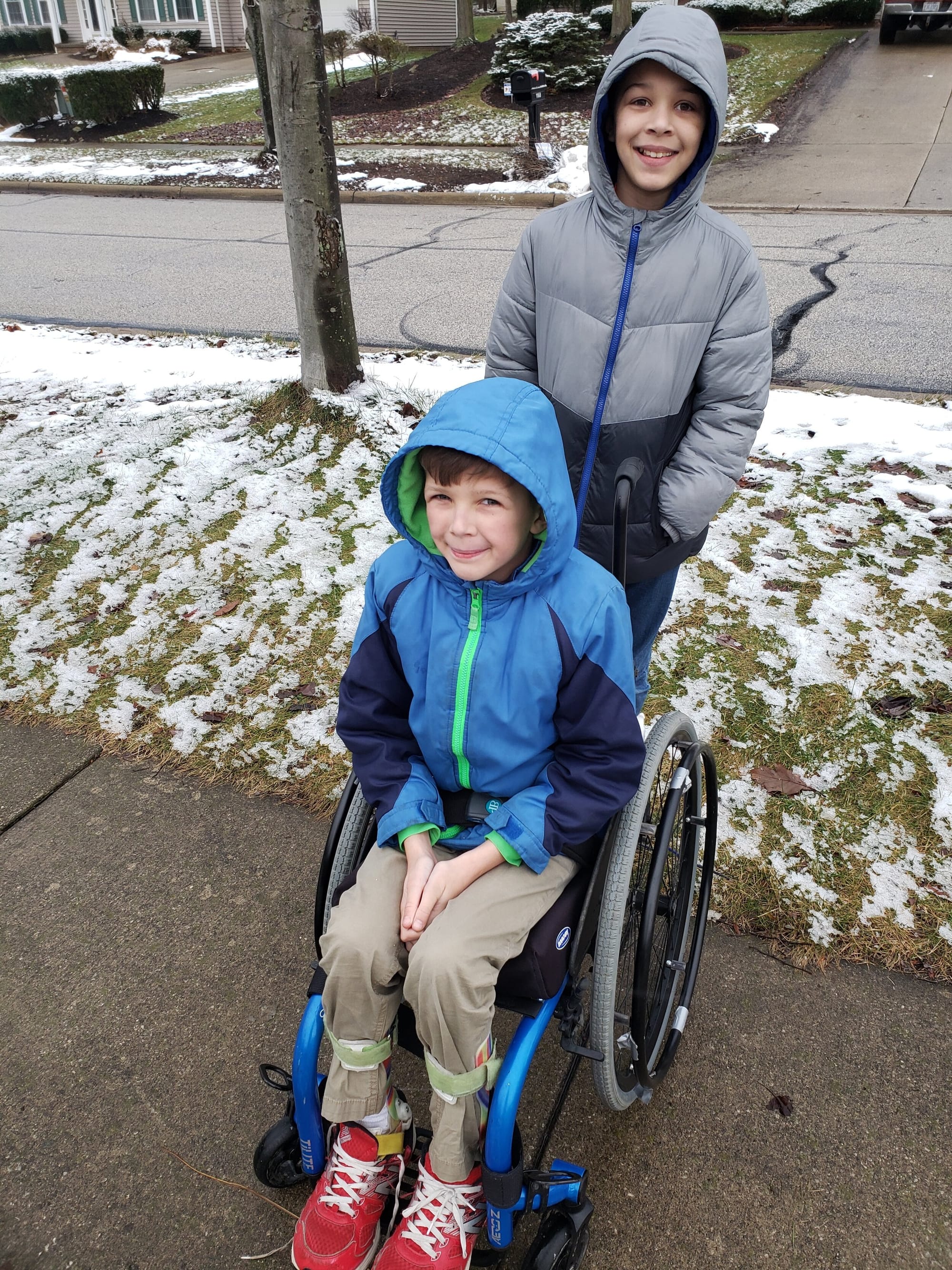 Julian with his wheels and his older brother Miles on a walk.