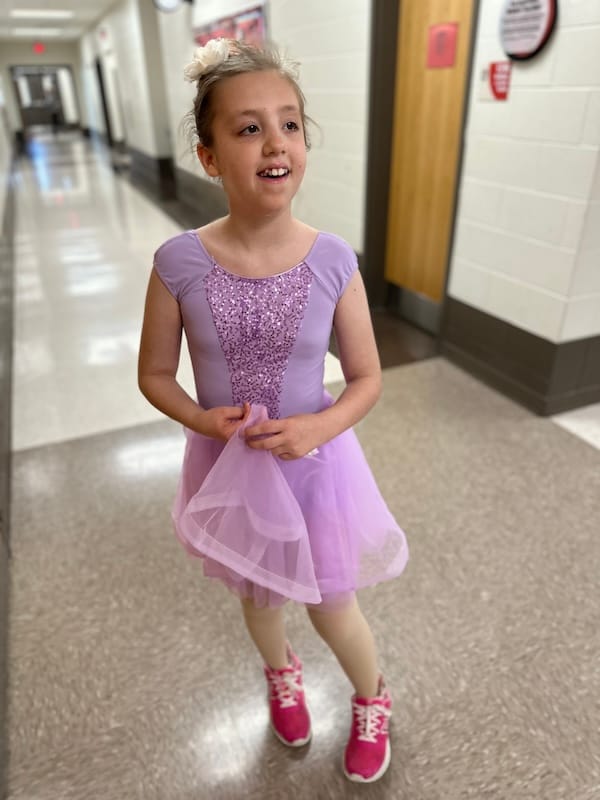 Audrey in a pink dance outfit with bright pink tennis shoes.