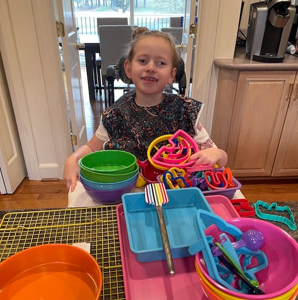 Olivia with a pile of colorful baking supplies.