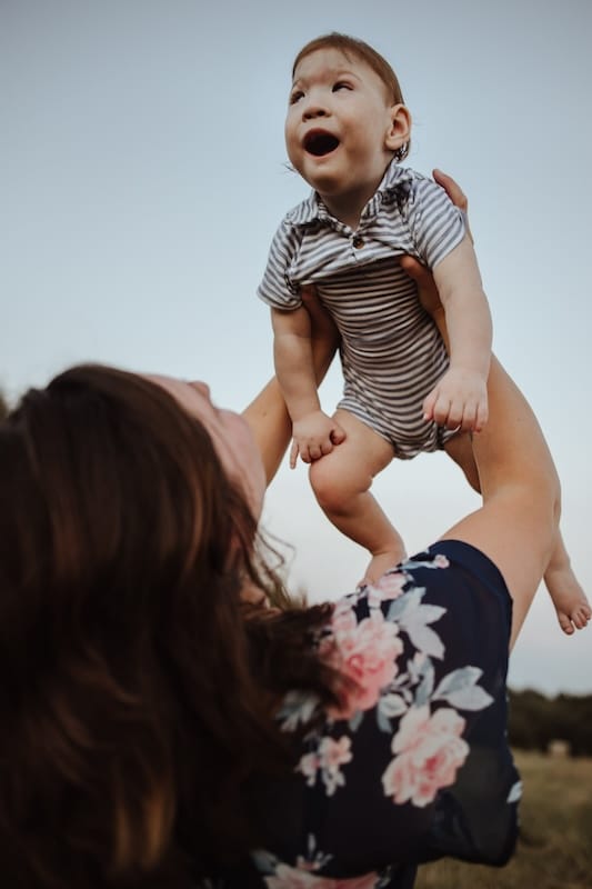 Logan as a baby, giggling as Mel tosses him in the air.