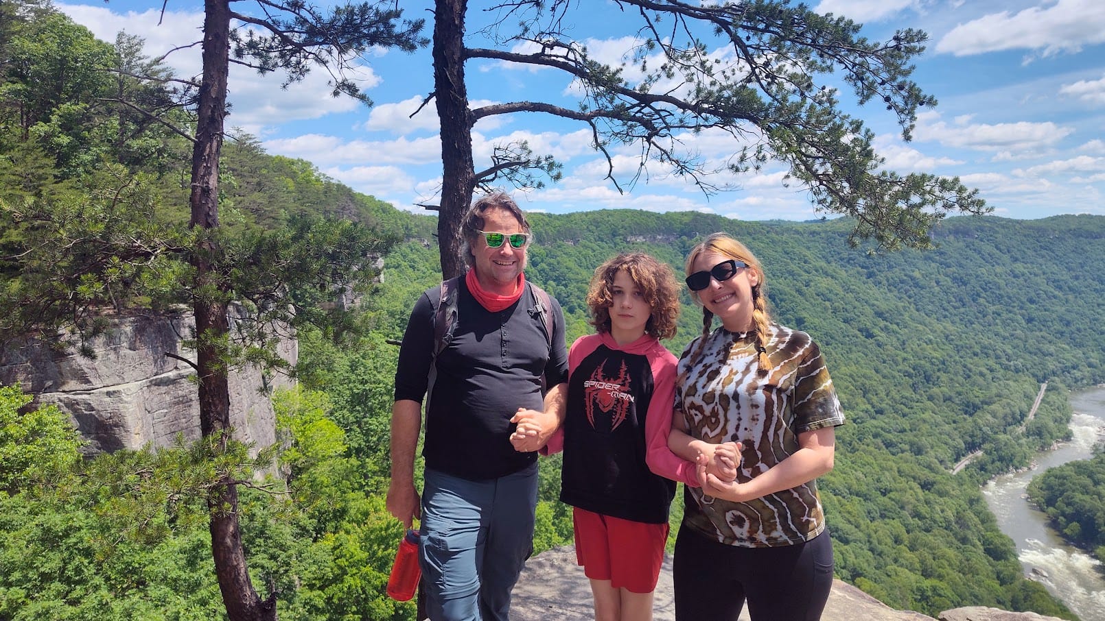 Lazaro on a hike with his family, smiling at a scenic overlook