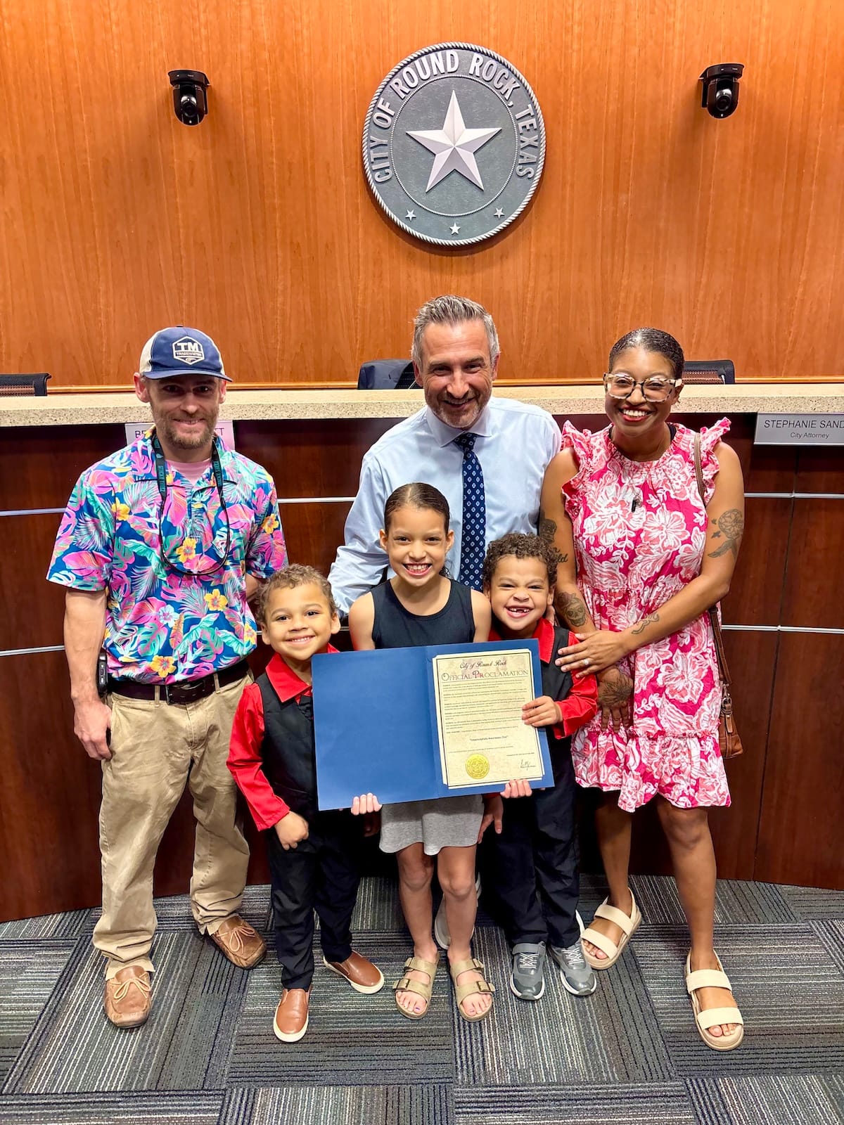 The Pittman family poses with an official proclamation at the City of Round Rock, Texas.