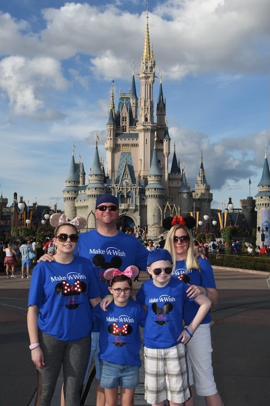Shannon, Ella, Riley, Victoria, and Shannon's husband Kevin in front of the iconic Disneyland castle on a Make-A-Wish trip.
