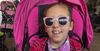 Audrey stylish in pink with big pink sunglasses and a bright smile.