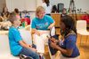Three smiling people in Little Lobbyists shirts sitting at a table.