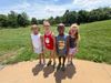 Four children outside, all smiling and wearing big glasses.