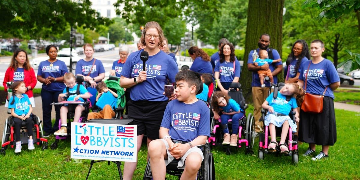 David and Maggie speaking at a popup event at the US Capitol. Maggie stands with a mic and David sits in his wheelchair.