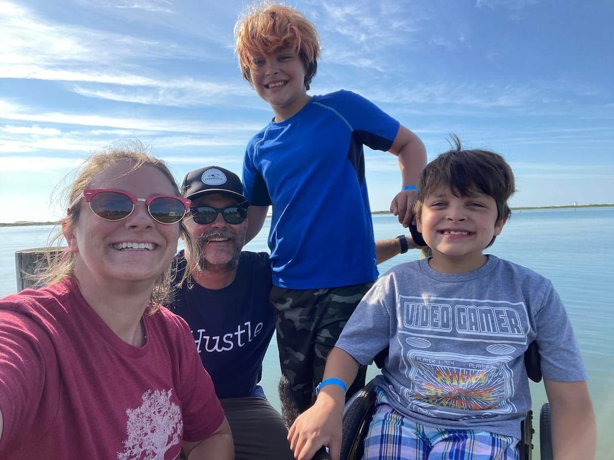 The Witzler family grins on a day at the beach.