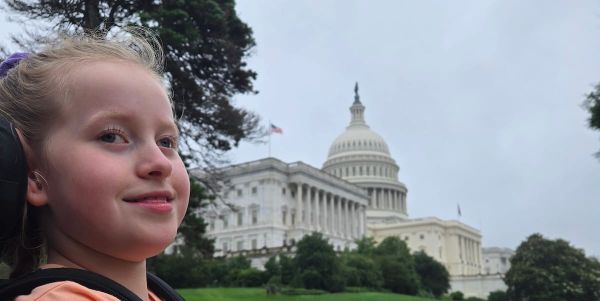 Olivia next to the US Capitol with a soft smile on her face. 