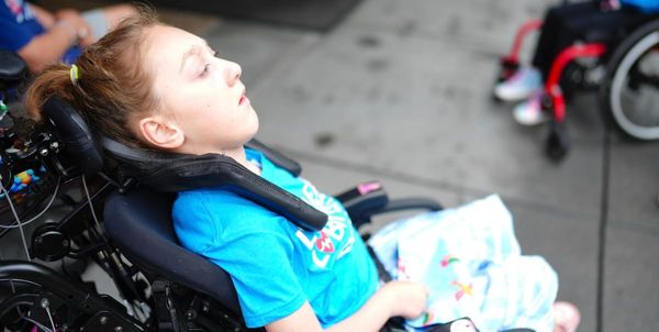 Olive in her wheelchair, wearing a Little Lobbyists shirt. 
