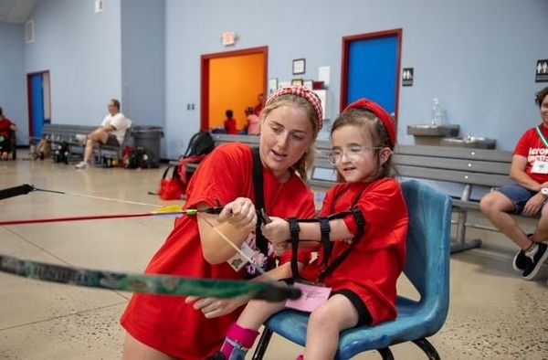 Kinsley and a friend preparing to shoot a bow and arrow.
