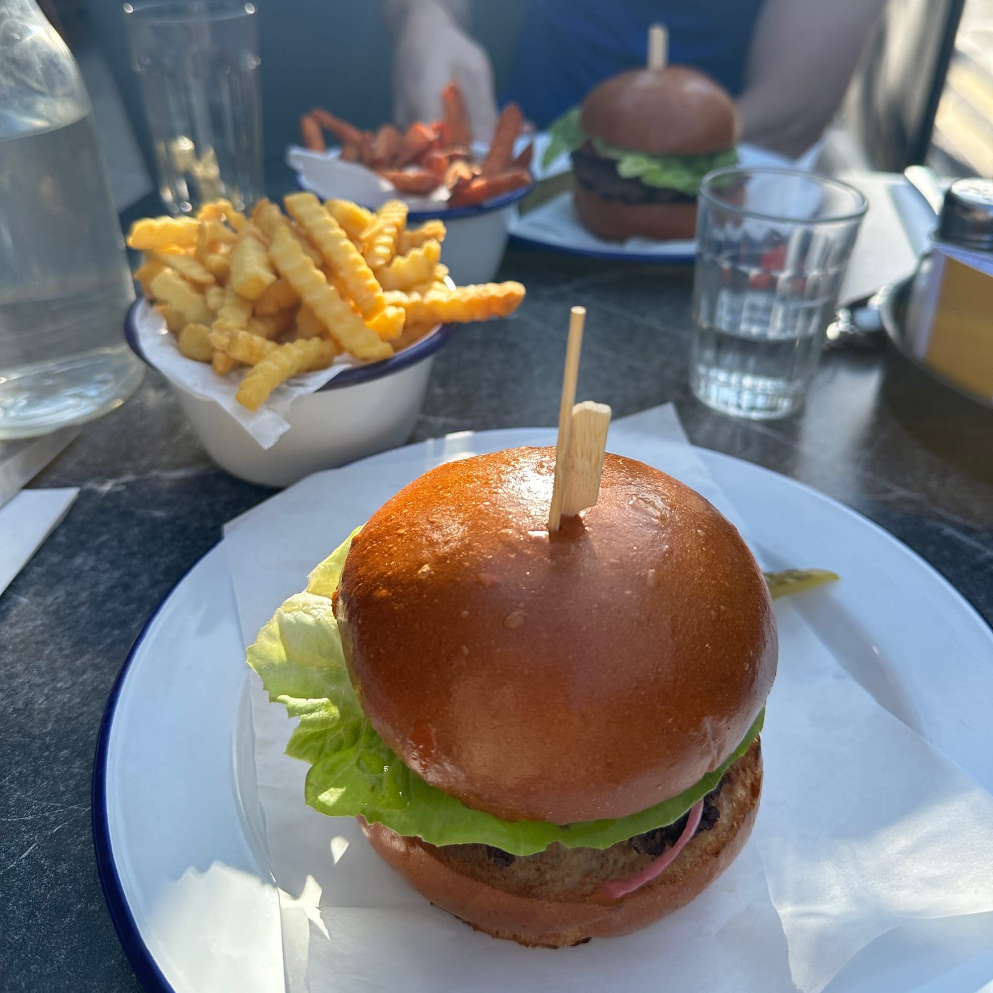 Two Cheeseburger and fries from Cork's Son of the Bun Restaurant dining al fresco