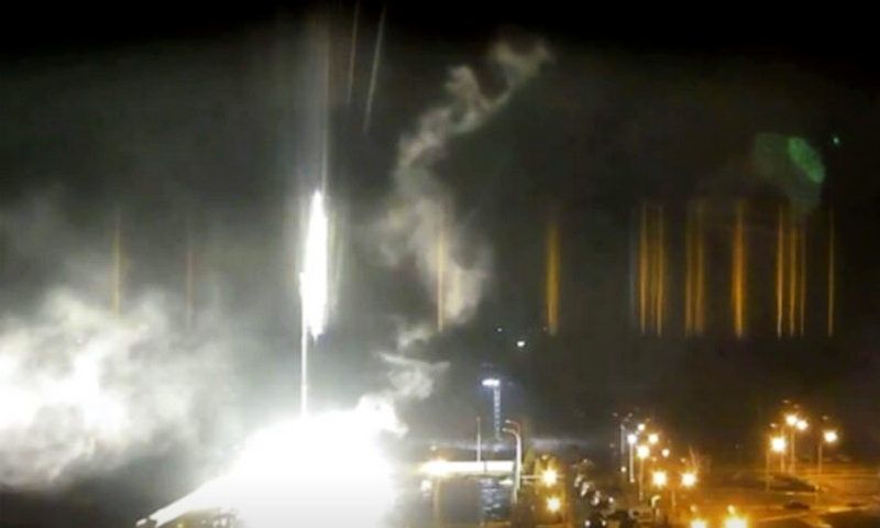 This image made from a video released by Zaporizhzhia nuclear power plant shows bright flaring object landing in grounds of the nuclear plant in Enerhodar, Ukraine Friday, March 4, 2022. (Zaporizhzhia nuclear power plant via AP)