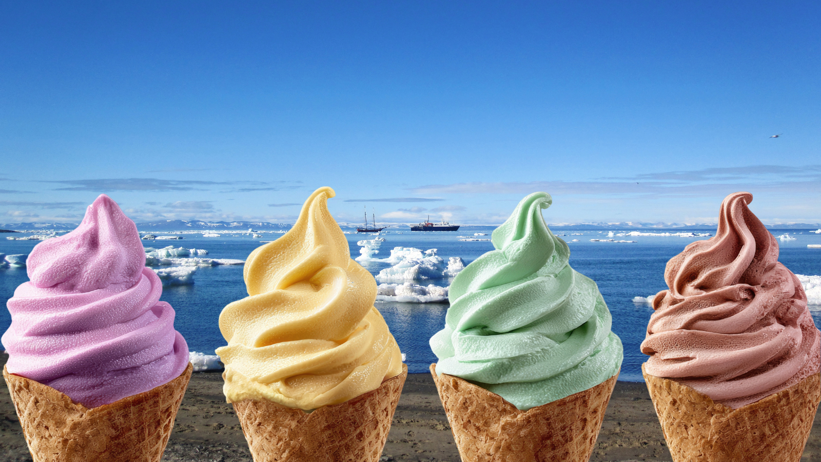 Four flavours of ice cream in cones in front of a beach and sea