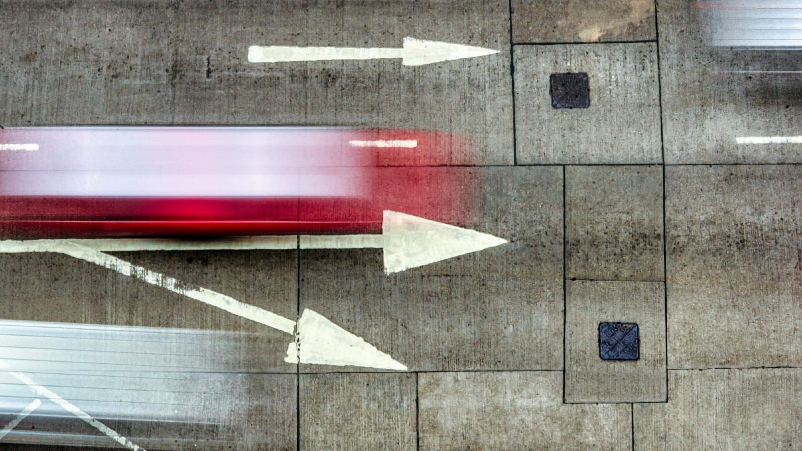 A paved road with arrows and blurred movement