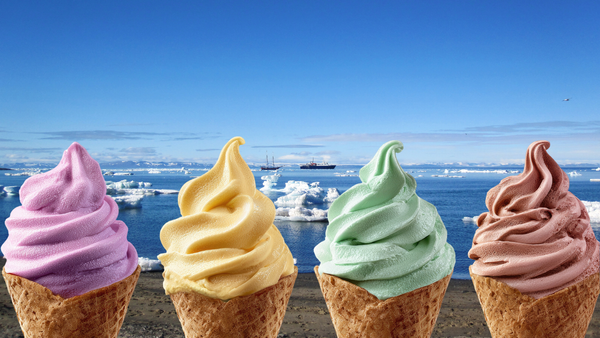 Four flavours of ice cream in cones in front of a beach and sea