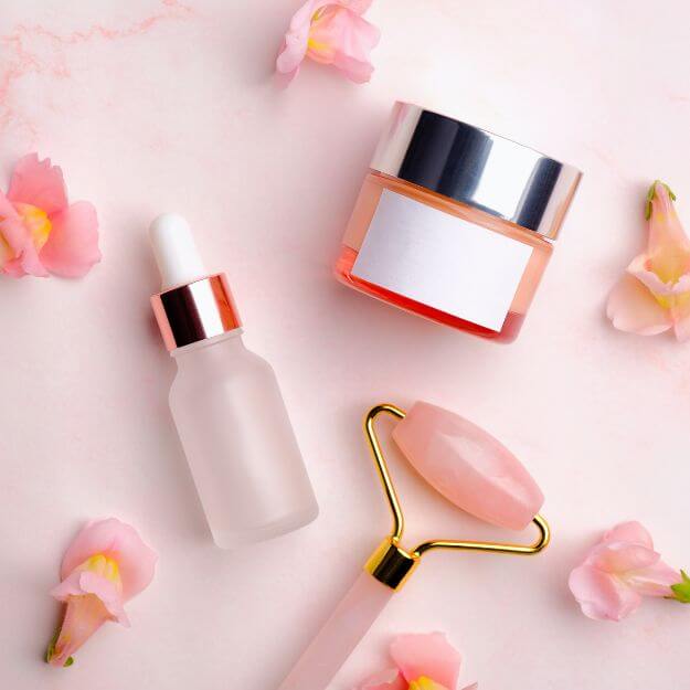 pink flowers, pink roller, bottle and glass jar