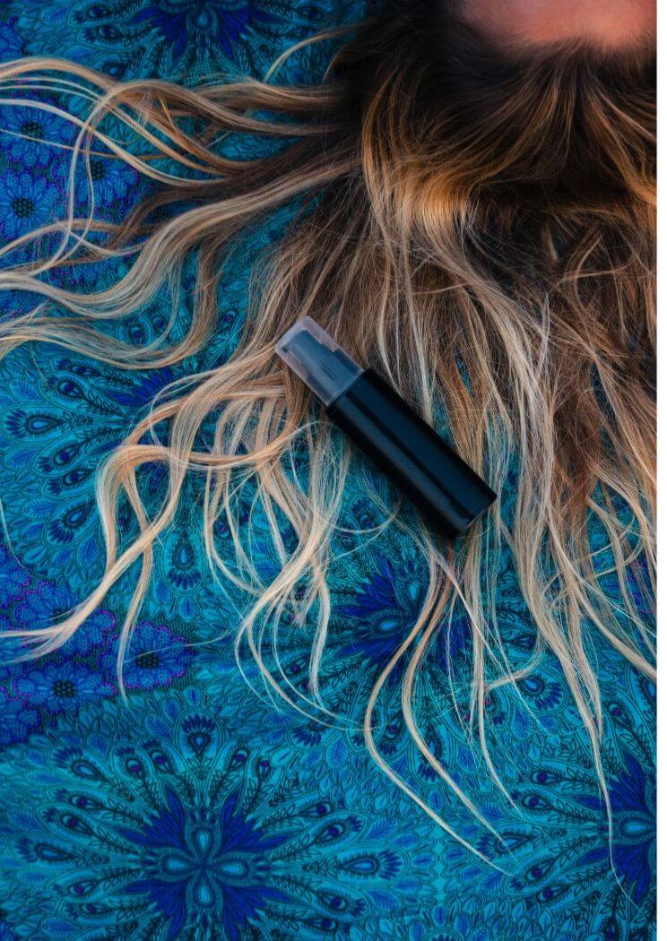 A woman with wet hair applying a nourishing hair mask