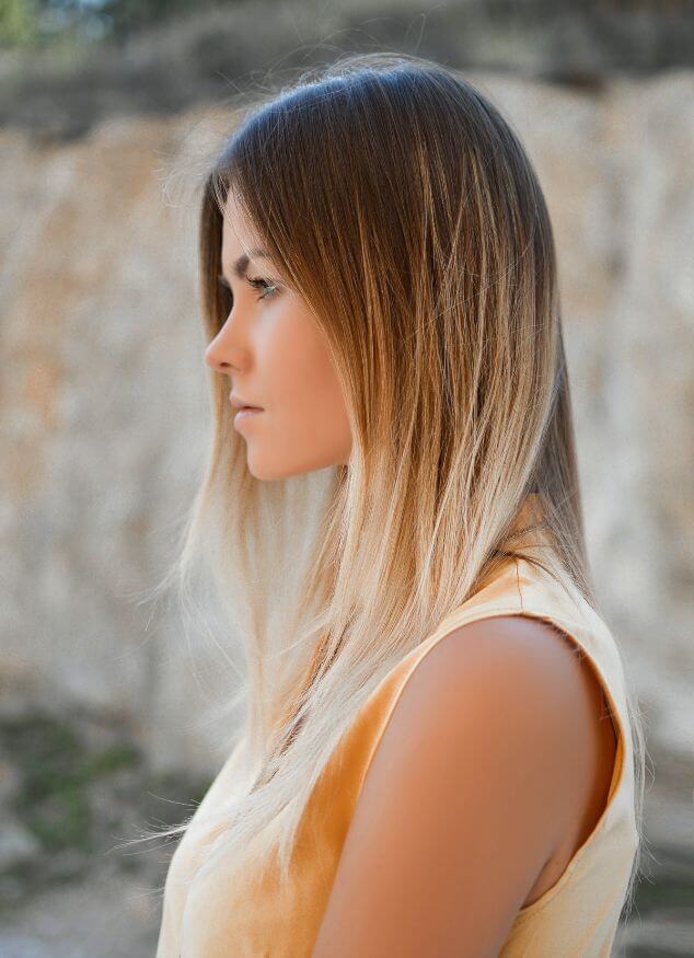 profile of blonde with yellow top looking of fin distance