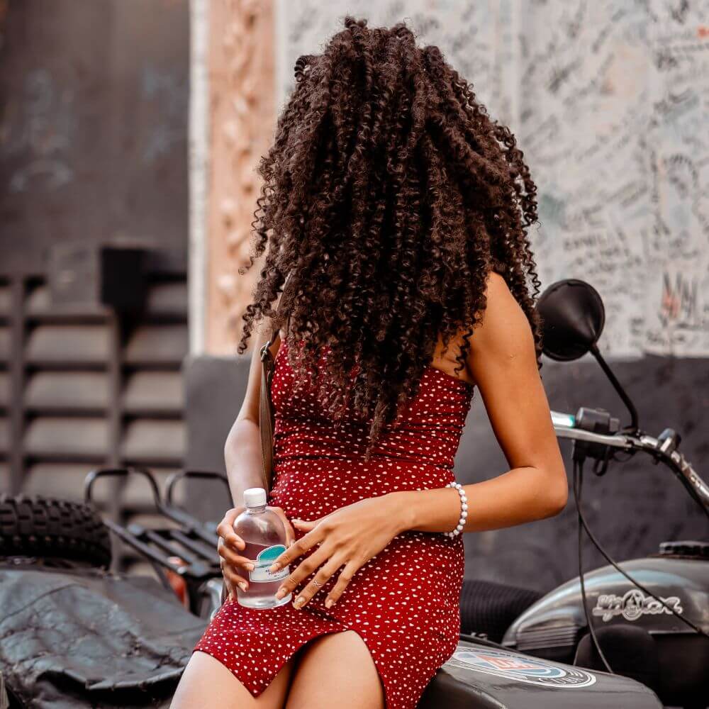 woman with cuban twist hair sitting on motorcycle