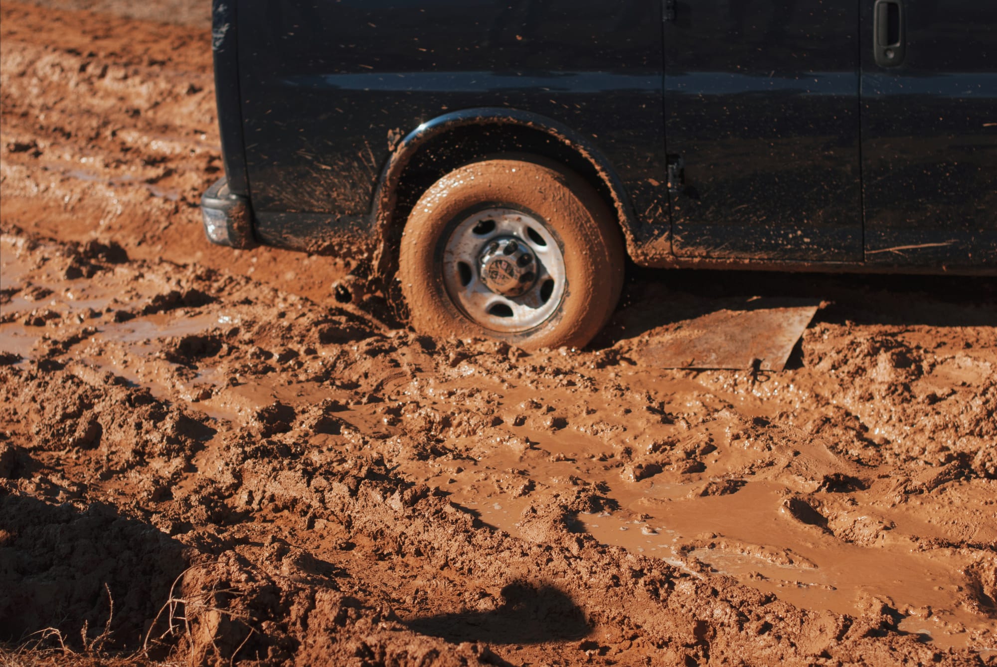 A truck spinning its wheels on a muddy road