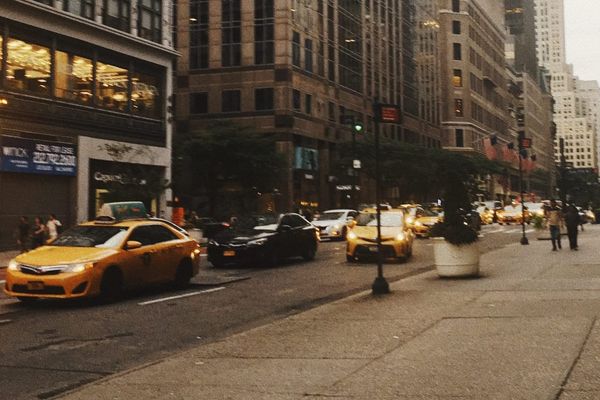 color street photography of neutral-colored buildings and yellow taxis in New York