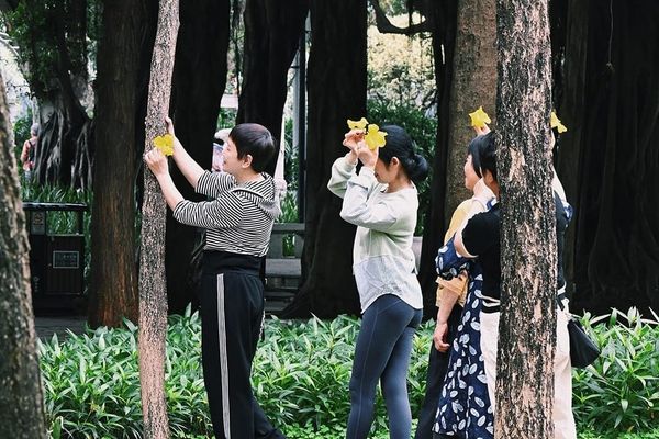 color street photography of women holding flowers posing for photos in a park
