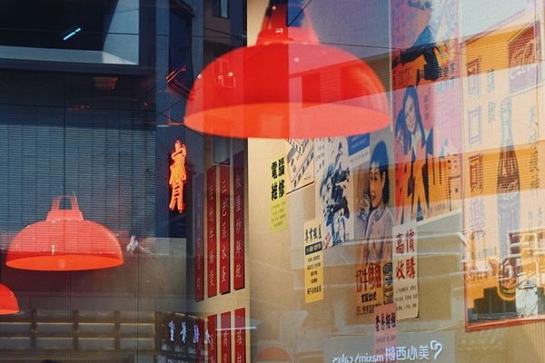 color street photography of red wet market lamps, vintage Hong Kong style posters, and window reflections of streets