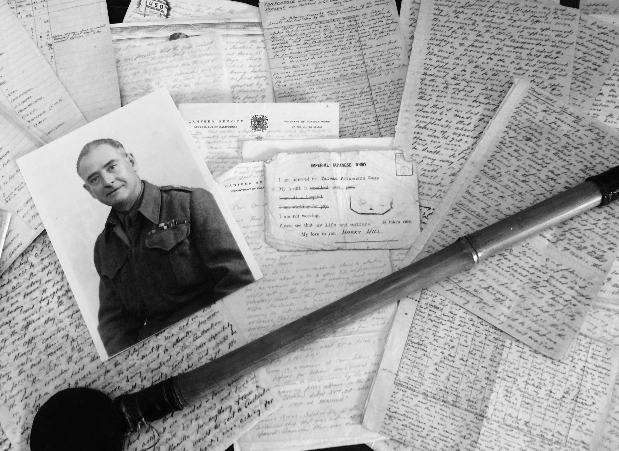 A collection of paper diary entries from Harry carefully laid out across a table together with a picture of him.