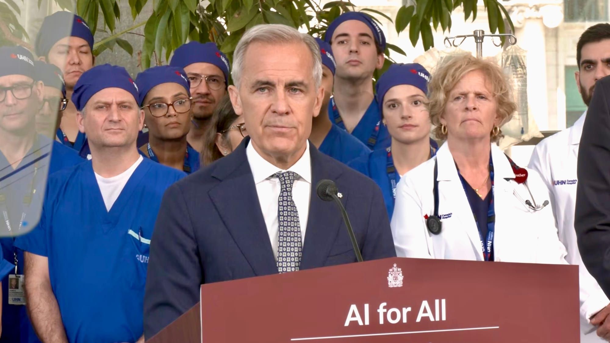 Mark Carney surrounded by doctors at the AI for All unveiling