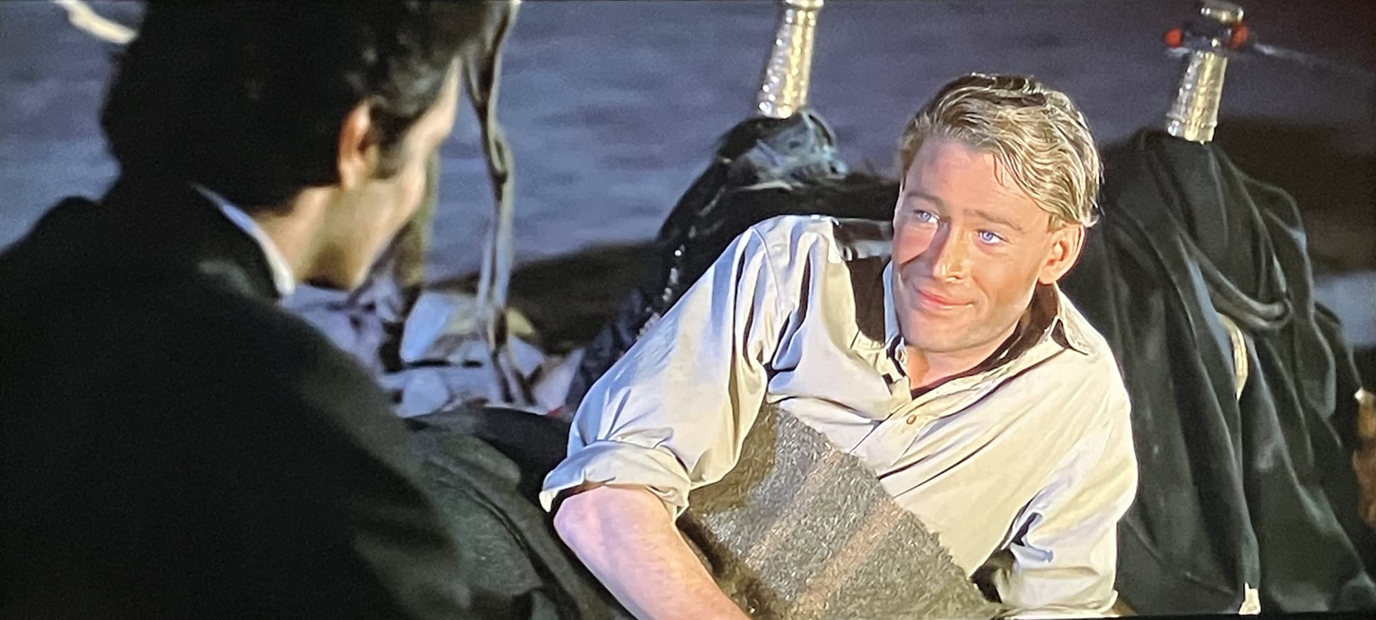 Peter O'Toole lying back and smiling at Omar Sharif in Lawrence of Arabia