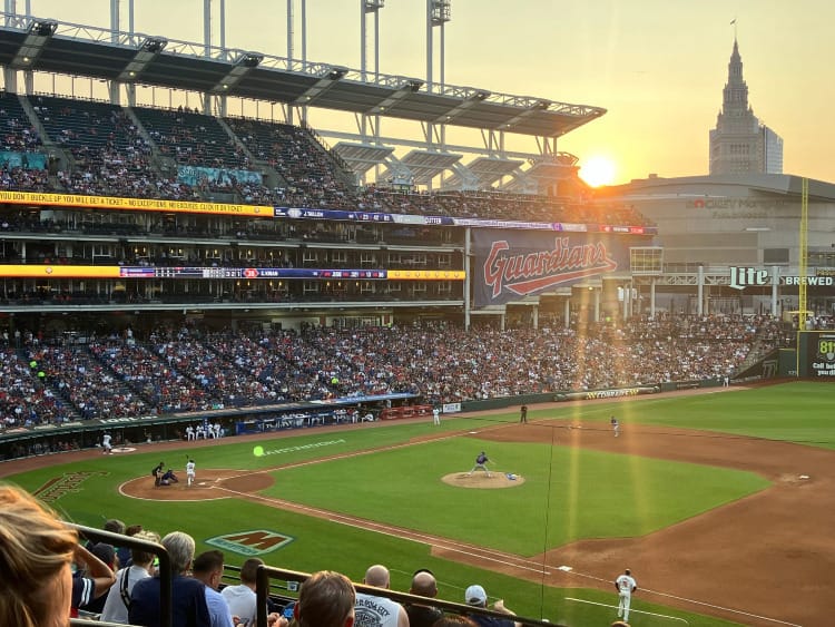 Rays of sunlight shining through the stands of Cleveland's Progressive Field, as a pitcher prepares to throw.