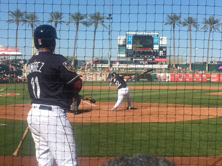 A spring training game. José Ramírez watches from the on-deck circle as Jason Kipnis hits one toward palm trees beyond the outfield.