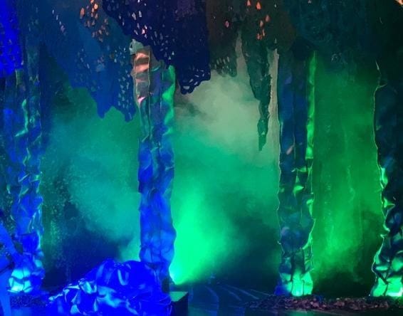 A stage with green and blue lights

Description automatically generated