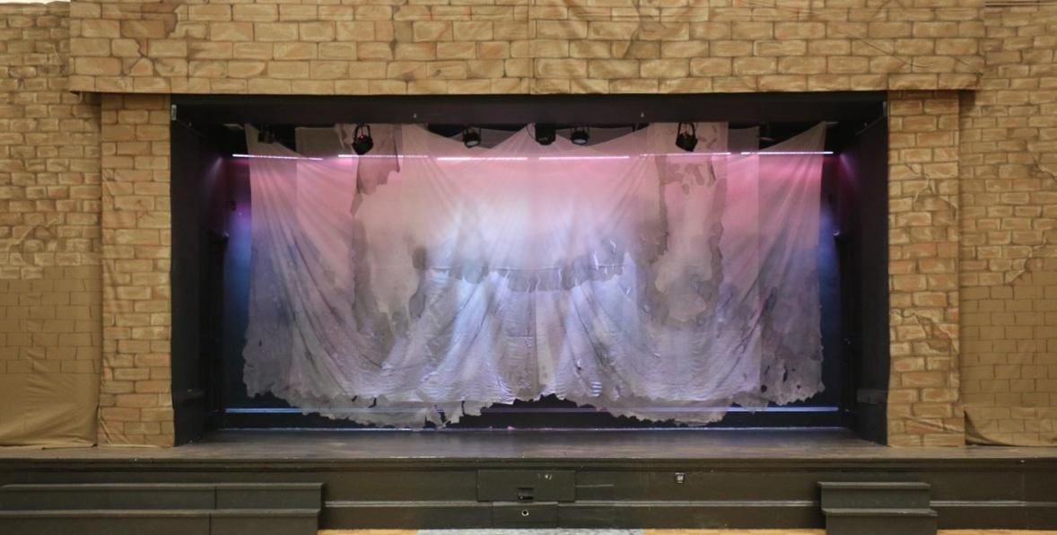 A stage with a curtain and lights

Description automatically generated