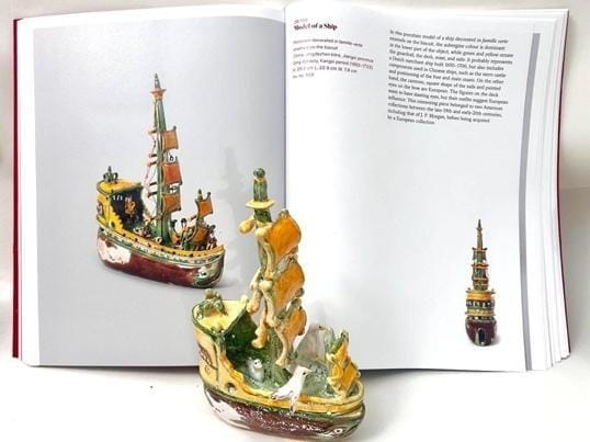 A book with a model of a ship

Description automatically generated
